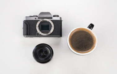 camera with lenses and mug of coffee on white background