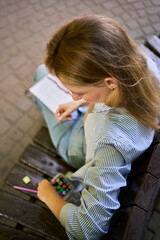 a young artist draws a sketch of a window on the streets of the city
