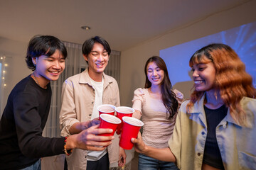 Fototapeta premium Group of Asian friends having evening party in living room at home. 