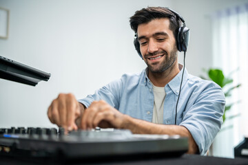 Caucasian man artist DJ mixing and scratching music mixer controller.