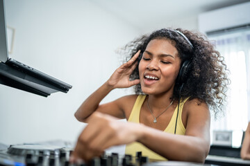 African American woman DJ mixing and scratching music mixer controller. 