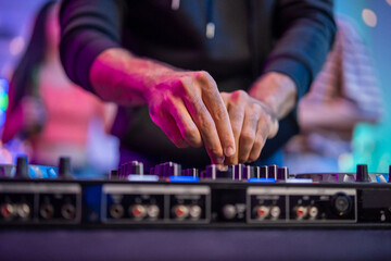 Close up of man artist DJ mixing and scratching music mixer controller. 