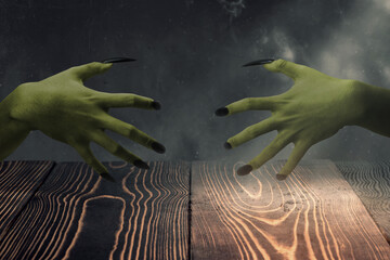 Two witches hand with long nail claw. The color is green. Evil, zombie, or monster hand is shown in...
