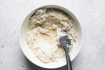 overhead view of dough for making nigerian egg roll in a white ceramic bowl, process of making nigerian egg roll and small chops