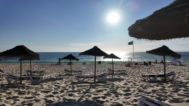 Beautiful beach scene in Comporta, Portugal on a bright summer vacation day, with clear blue skies, soft golden sand, and gentle ocean waves. 