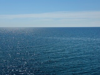 Sea blue shiny water and clear sunny sky.