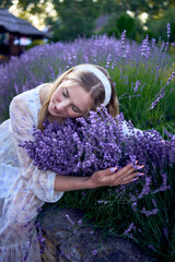 portrait of a young blonde woman in a pastel chiffon dress among lavender bushes