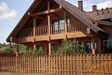 Approximation of a modern wooden house made of wood and a wooden fence
