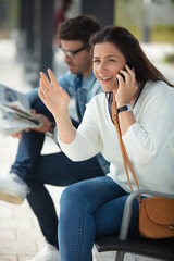 happy girl on a smartphone while waiting for a train