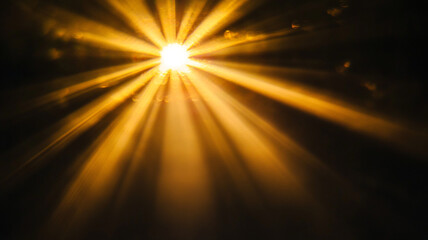 Golden rays of light streaming through darkness, creating a warm and ethereal atmosphere