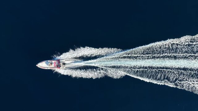 Aerial overhead view of a RIB Boat with outboard engine crossing the blue ocean with speed