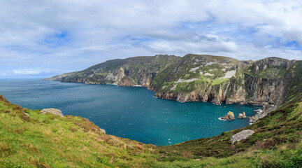 Fototapeta premium Panoramic view of Slieve League cliffs in Ireland with rugged coastal landscape, steep cliffs, and clear blue waters of the Atlantic