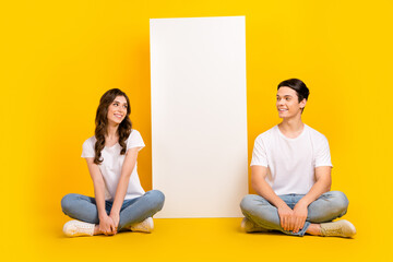 Full length photo of excited dreamy husband wife dressed white t-shirts reading device empty space isolated yellow color background