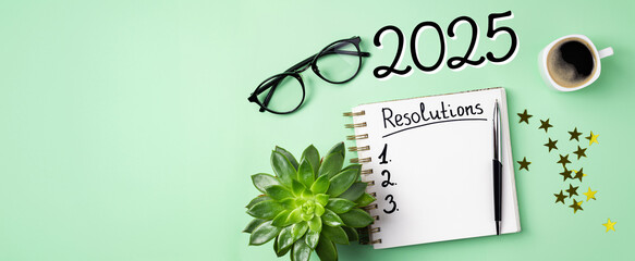 New year resolutions 2025 on desk. 2025 resolutions list with notebook, coffee cup on table. Goals,...