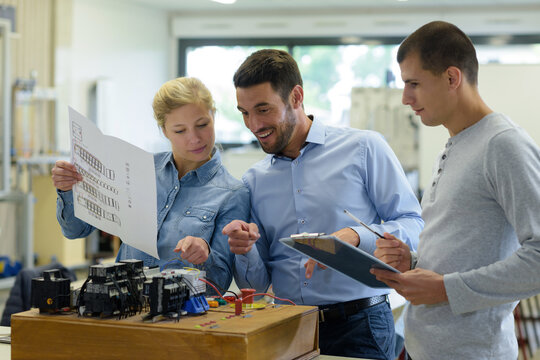 students taking notes in engineering laboratory with teacher
