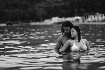 Fototapeta premium couple in love in water swim in the sea in the evening and love each other, long-haired couple.