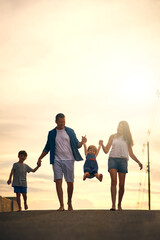Fototapeta premium Love, support and holding hands with family walking in street for solidarity, bonding and peace. Sunset, calm and summer vacation with people in neighborhood for children, happiness and mockup
