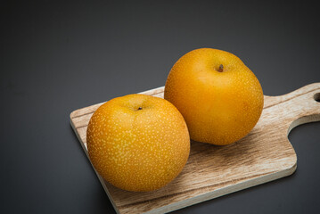 果汁が滴る食べ頃の日本の梨を、カッティングボードにのせて