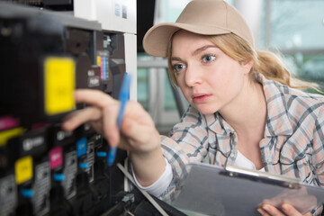 female technician checking printer