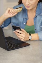 woman doing shopping online holding smartphone and credit card