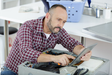 plumber with clipboard near washing machine