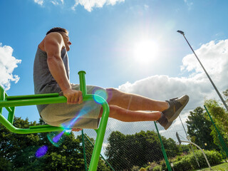 Man doing legs exercises in outdoor gym