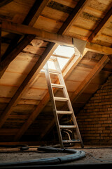 House attic renovation. Roof construction planks with ladders
