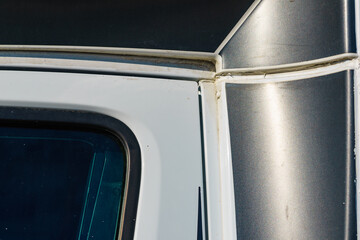 Old silicone sealant around the edges of caravan.