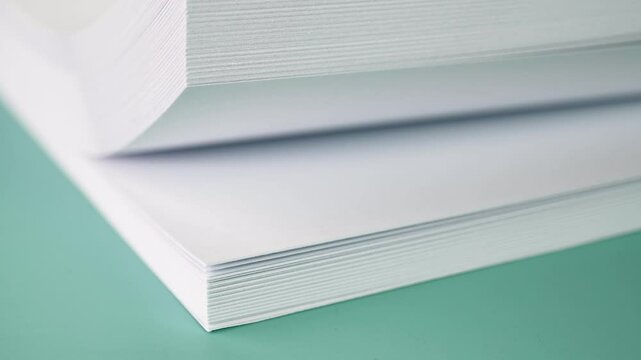 Flipping stack of papers on a desk.