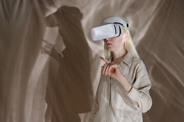 Medium shot of young woman with albinism wearing beige clothes standing in studio decorated with...