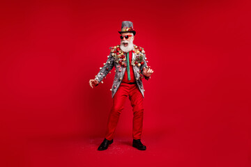Full size photo of happy cheerful old man dancing good mood wear christmas tree balls costume sunglasses isolated red color background