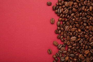 Roasted coffee beans on red background. Space for text