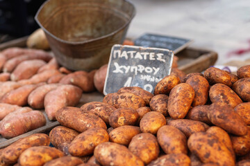 A vibrant display of freshly harvested sweet potatoes fills the market stall, highlighting their earthy tones and unique shapes, attracting shoppers eager for local produce.