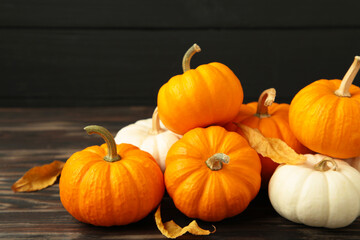 Festive autumn decor from pumpkins and leaves on black wooden background. Concept of Thanksgiving day or Halloween.