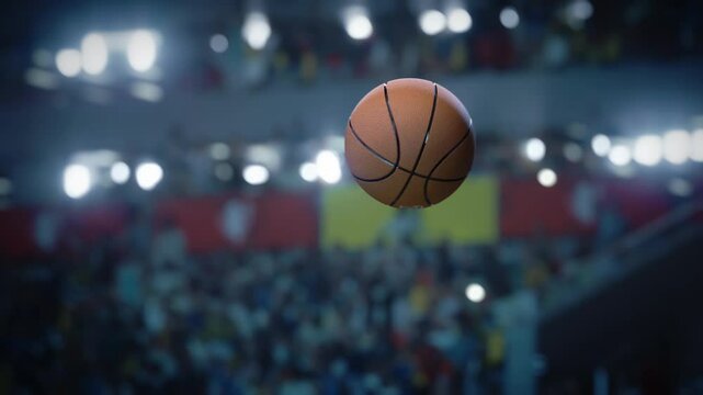 Basketball Ball in flight towards the Winning last Second Score. Ball's Motion Against a Blurred Stadium Backdrop, Championship with Crowd of Cheering Fans. Focus Tracking Shot on the Slow Motion ball