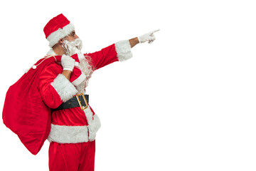 Santa Claus seen from the side holding a sack of gifts while pointing with his finger to copy space