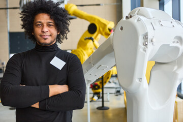 Engineer at robotics lab developing and programming multipurpose robotic arms for industrial...