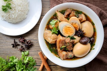 Seasoned eggs, hard boiled eggs with pork belly and white rice in Chinese Five Spices Sauce,Five Spice Egg with pork, thai called kai pa lo, boiled eggs and pork in brown soup