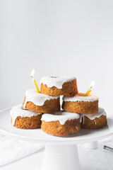 Iced mini bundt cakes on a white plate, vanilla bundlette on a plate, small vanilla bundt cakes with an icing glaze