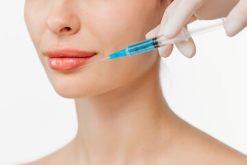 A doctor's hands holding a syringe near a woman's face as she receives a skin lifting injection. This moment emphasizes beauty and modern skincare techniques for a radiant appearance.