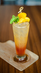 isolated a glass of cold peach tea on the brown table with sliced ​​peaches. served cold and refreshing. Perfect for menu, catalogue, advertising or commercial use