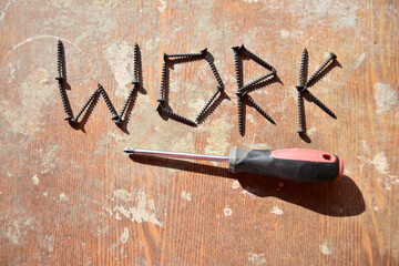 single screwdriver under the word work made of screws