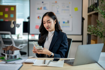 A woman in a business suit is looking at a stack of money