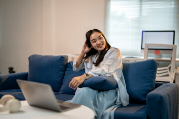 Obraz premium A woman is sitting on a blue couch with her hair in her hands