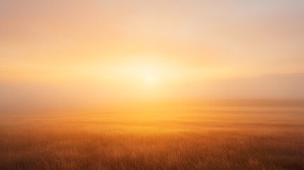 A tranquil and picturesque landscape at sunrise with golden sunlight breaking through light mist over a calm field as the sky is painted in soft hues of orange and pink