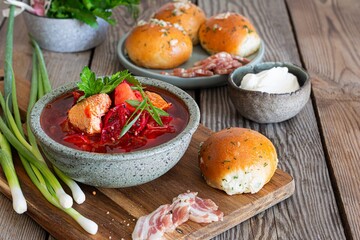 National dish of Ukrainian cuisine borscht with vegetables, turkey meat, herbs, sour cream and traditional bread (bun with garlic and dill, pampushka) with bacon (pork). Cultural heritage.
