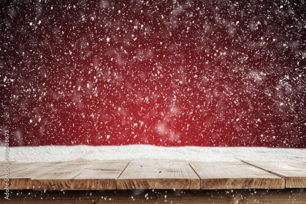 Wall mural wooden table with empty copy space and red christmas background with snowflakes