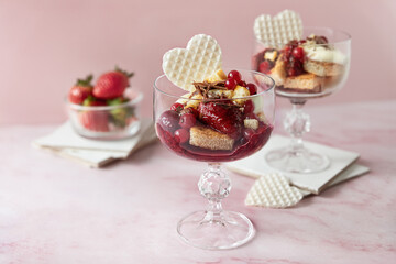 Strawberry trifles on pink background, simple fruit dessert served in glasses