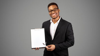 African American Man Showing Blank Clipboard, Pointing At Copy Space With Pen. Panorama