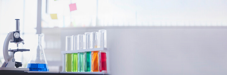 Banner Science laboratory chemistry test science lab with microscope glass tubes chemical beaker scientific background. Colorful Liquid biology laboratory fluid scientist experiment with copy space